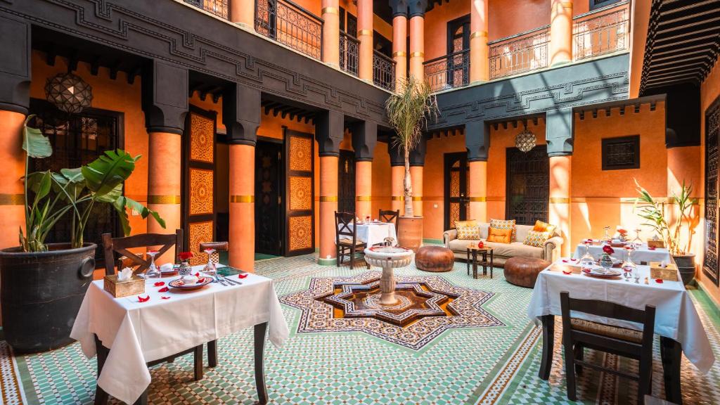 a restaurant with tables and chairs in a building at Riad Sultan Suleiman & Spa in Marrakesh