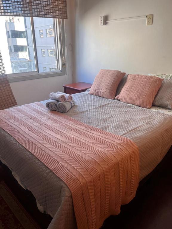 a bedroom with a bed with a stuffed animal on it at Flat na Orla do Guaíba com Piscina e Camareira in Porto Alegre