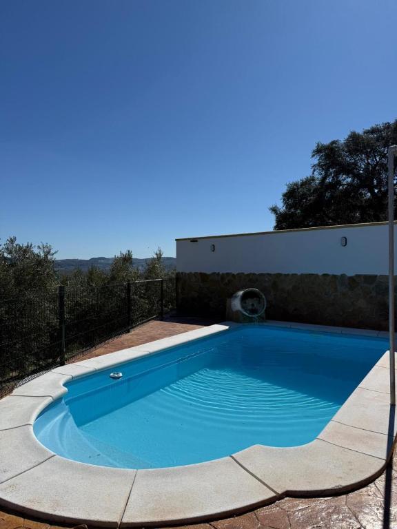a swimming pool in a yard with a fence at Cortijo El Nevazo II in Fuentes de Cesna