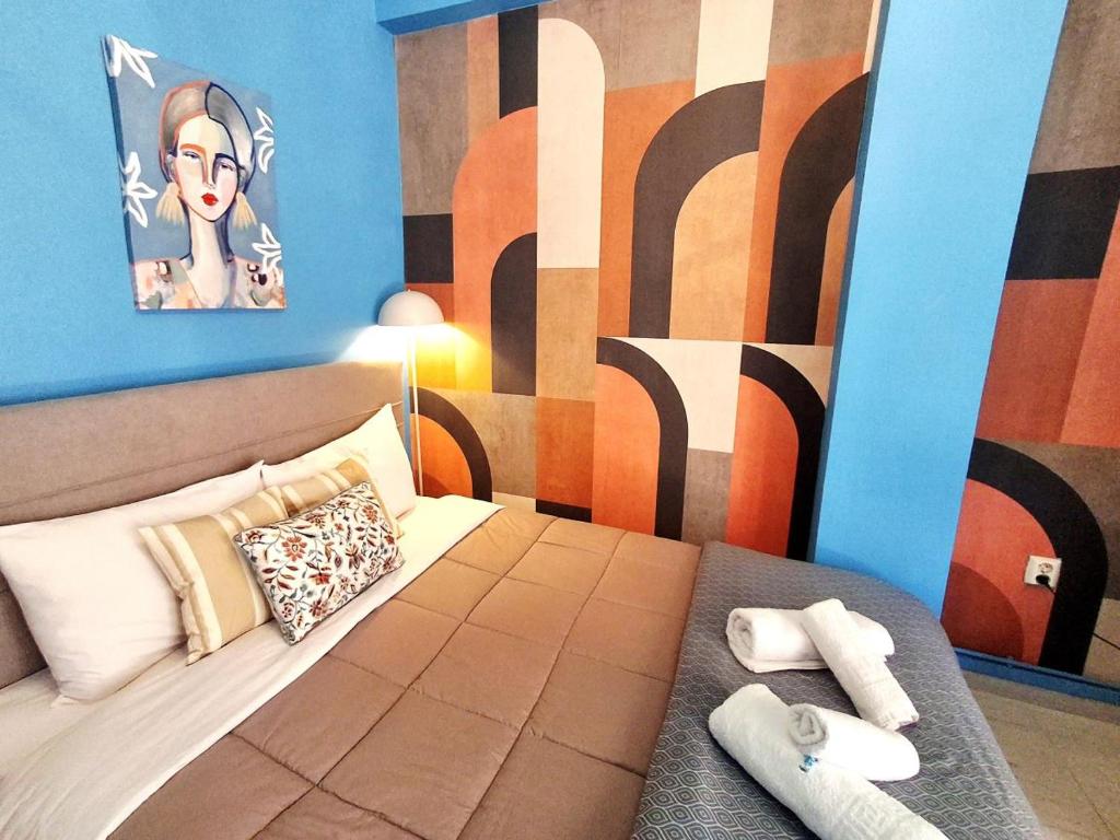 a bedroom with a bed with a painting on the wall at SuiteArtate in Patra