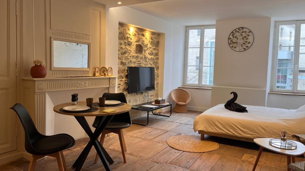 a room with a bed and a table and chairs at L'été sans fin in Bellac