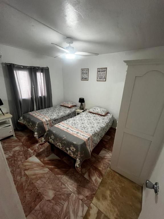 a room with two beds and a door at Mawoon House in Friar's Bay