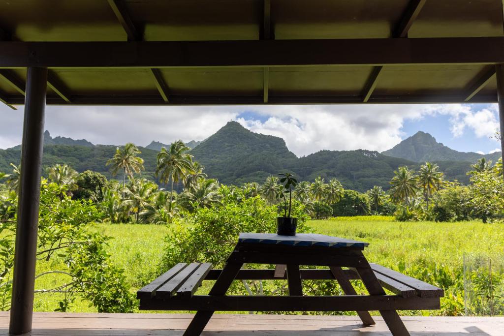 a bench sitting on a porch with mountains in the background at Hidden Haven - Group Retreat-Sleeps 7 aircon & free Wifi in Rarotonga