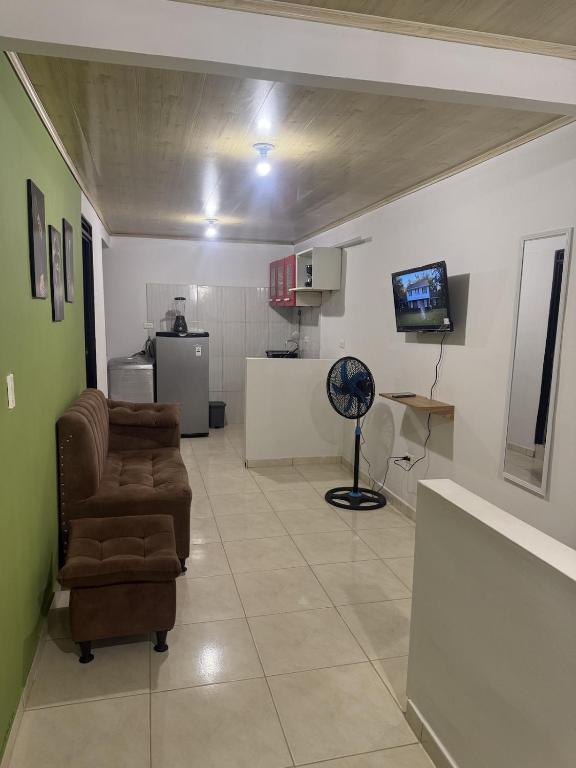 a living room with a couch and a fan at La Estancia Tolimense in Ibagué