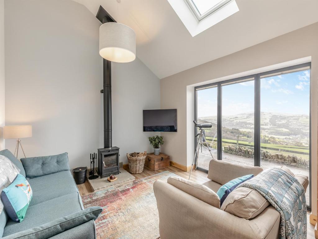a living room with a couch and a fireplace at Shutlingsloe in Mellor