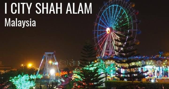 a ferris wheel and a christmas tree at night at QH Guesthouse in Shah Alam