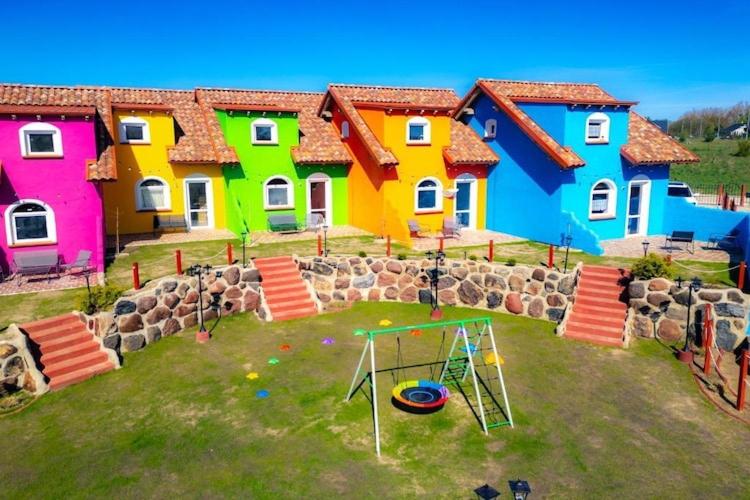 a group of colorful houses with a playground at Mexican-themed holiday homes in Debina