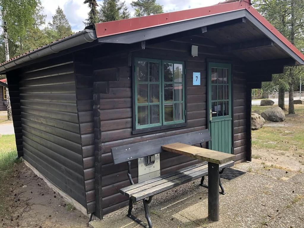 a small cabin with a bench in front of it at Bernsteinsee Home and Ferien Small Forest Chalet in Sassenburg