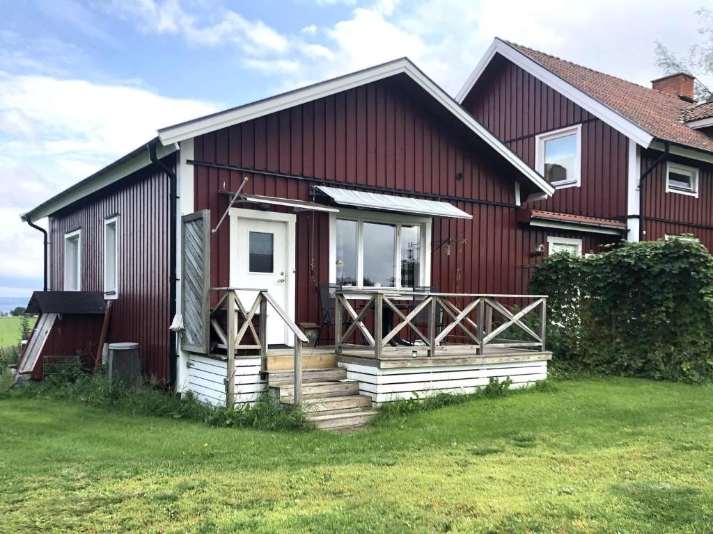 a red house with a white door and a porch at Charming Red Farmhouse Near Forsheda in Krokom