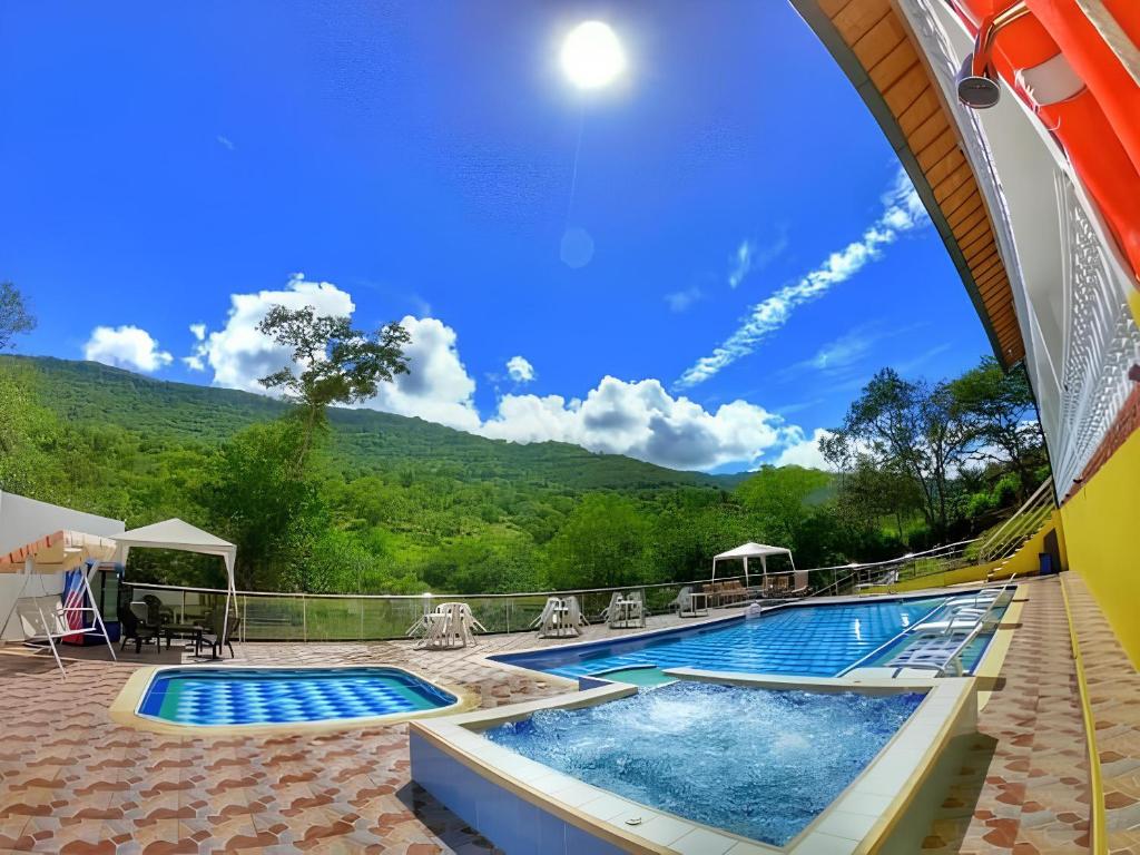 a swimming pool with a mountain in the background at Sea Natural in San Gil