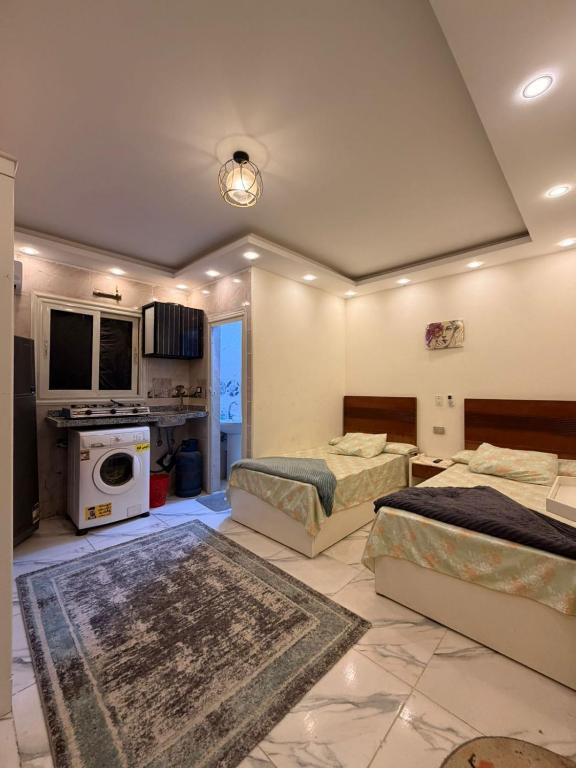 a large room with two beds and a kitchen at فندق العجمي 100 in 6th Of October