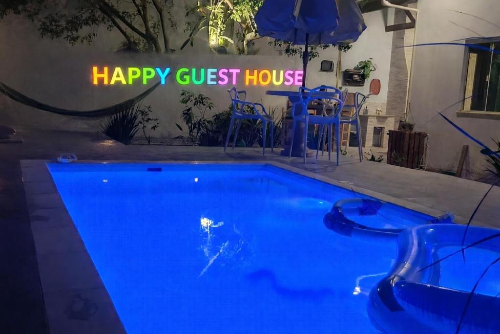 a sign that reads happy guest house next to a swimming pool at Happy GUEST House Beto Carrero in Navegantes