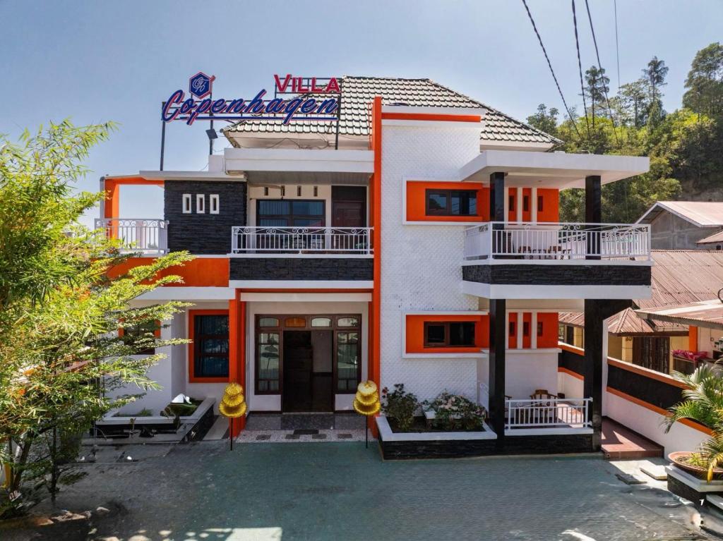 an orange and white building with a sign on it at Villa Copenhagen Bukittinggi in Bukittinggi