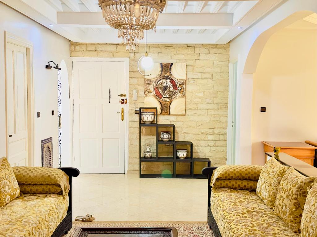 a living room with two couches and a chandelier at spacieuse vacation appartements in Essaouira