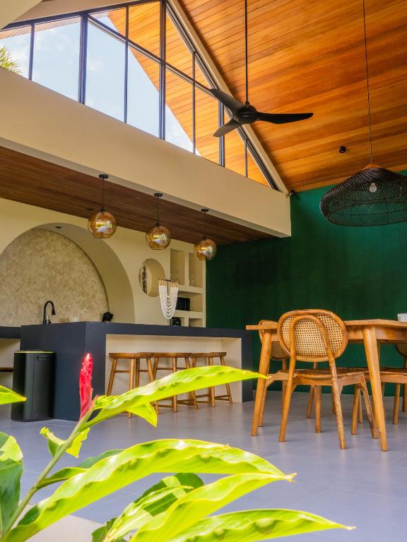 a dining room with wooden ceilings and green walls at Villa Sun Soul - Brand New 2bed Villa w Rice Field View in Ubud