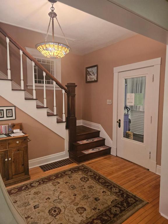 a living room with a staircase and a chandelier at Waterfront The Hearding Island in Duluth