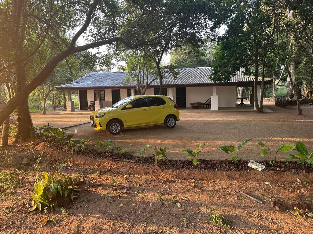 a small yellow car parked in front of a building at Emerald Hotel Sigiriya in Dambulla