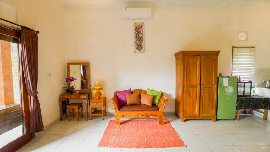 a living room with a chair and a cabinet at The Oding House in Ubud