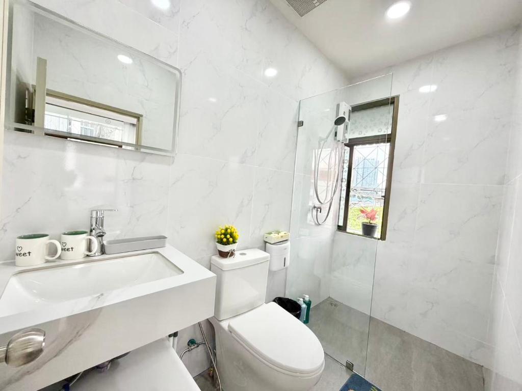a white bathroom with a toilet and a sink at S Hostel sukhumvit48 Near Phrakanong BTS 2001 in Bangkok