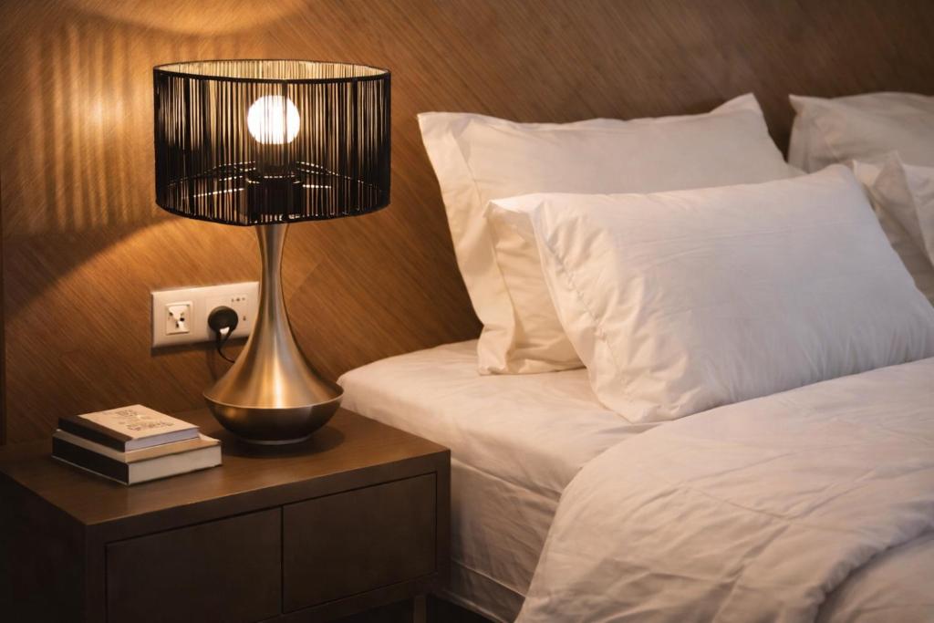 a lamp on a night stand next to a bed at Tunjong Stay in Kota Bharu