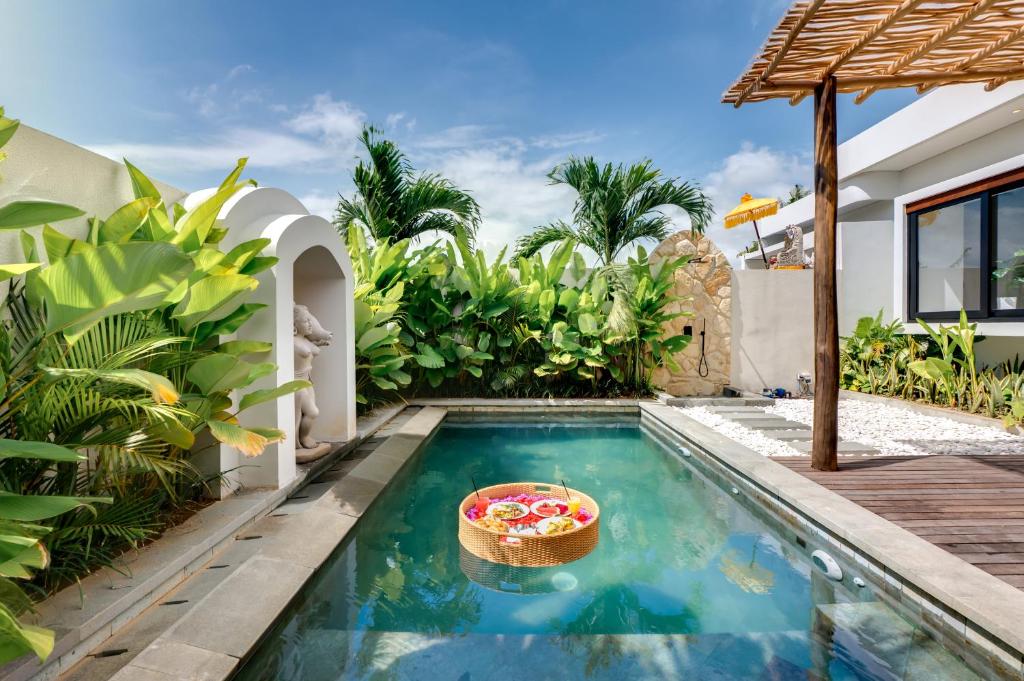 a swimming pool with a basket of fruit in a house at Tresna Villa Tumbak Bayuh Utara in Dalung