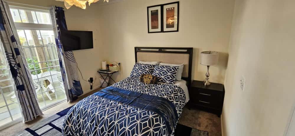 a bedroom with a bed with a blue and white comforter at Single Room in Townhouse in Manassas