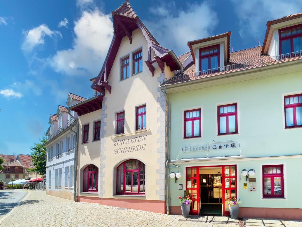 a large white building with red windows on a street at Zur Alten Schmiede in Naumburg