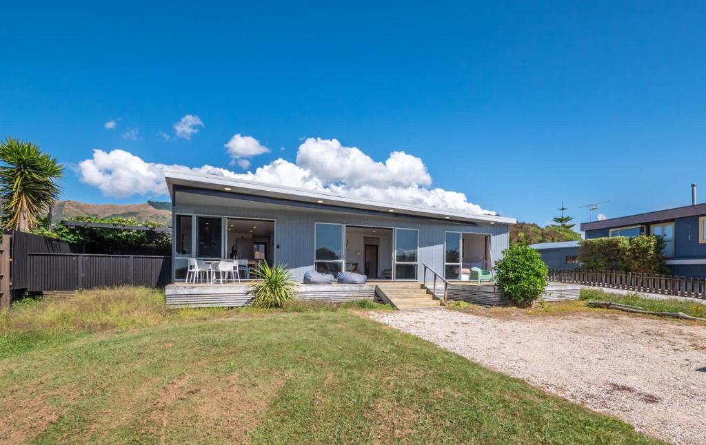 a house with a porch and a yard at Pohara's Beachside Bliss in Pohara