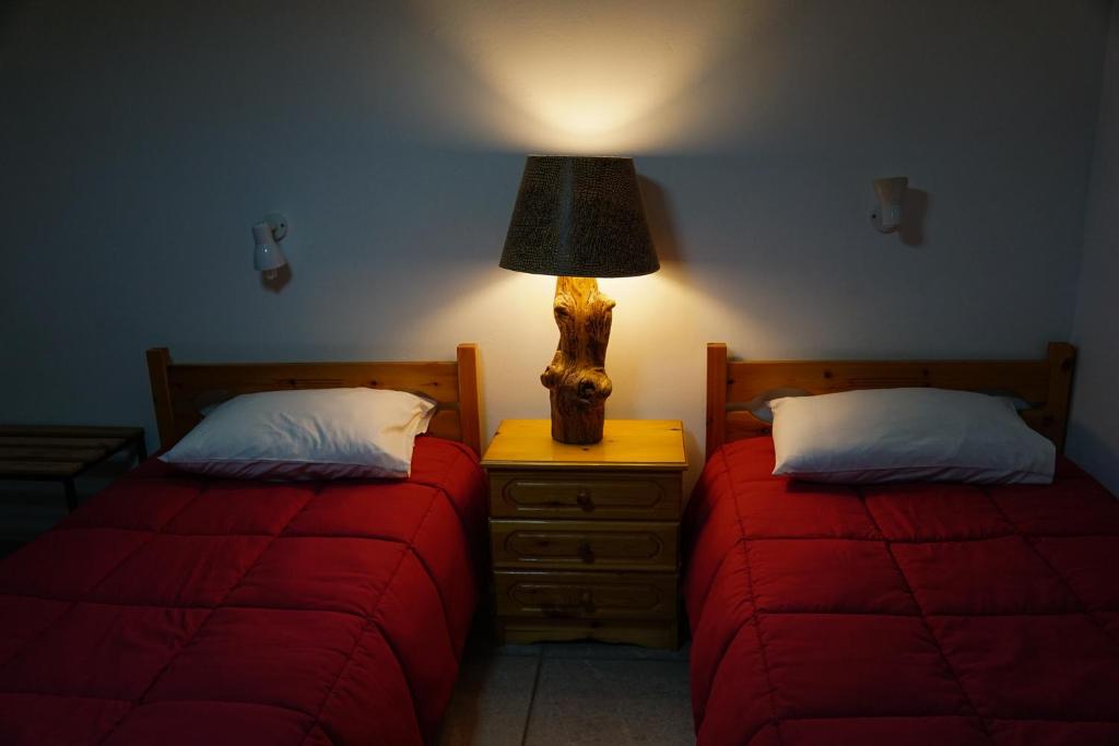 een slaapkamer met 2 bedden en een lamp op een nachtkastje bij Elatos in Loutra Ipatis