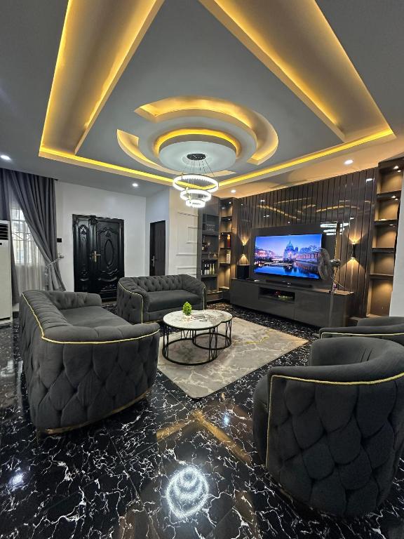 a living room with couches and a flat screen tv at EIMACK APARTMENT Service in Asaba