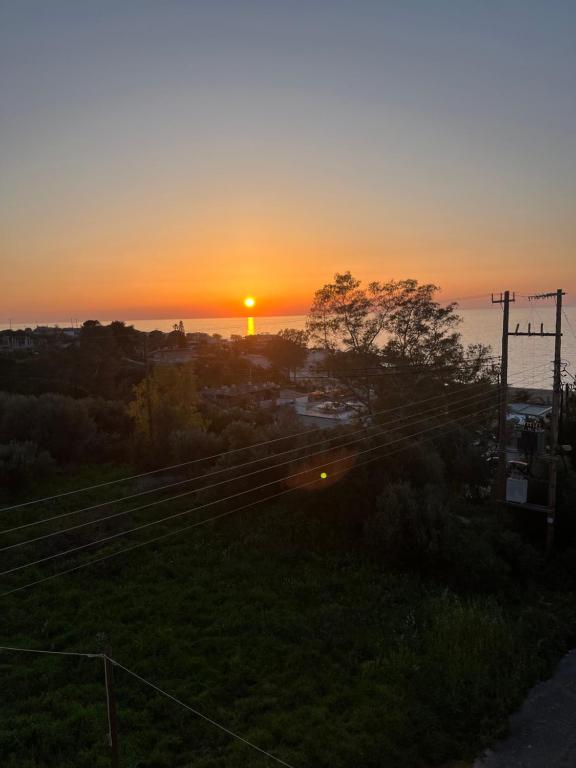 a sunset over the ocean with the sun setting at STUDIO WITH SEA VIEW - KYPARISSIA beach in Kyparissia
