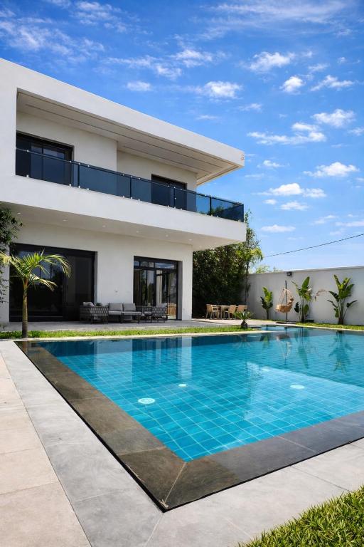 a swimming pool in front of a house at Villa de luxe piscine chauffée & Jacuzzi & Petit déjeuner in Fez
