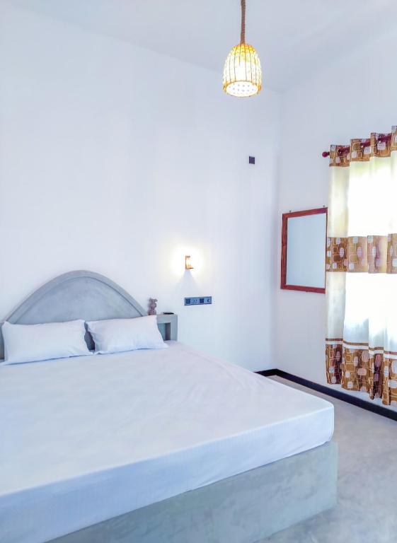 a white bedroom with a large white bed in it at YK House Midigama in Midigama East