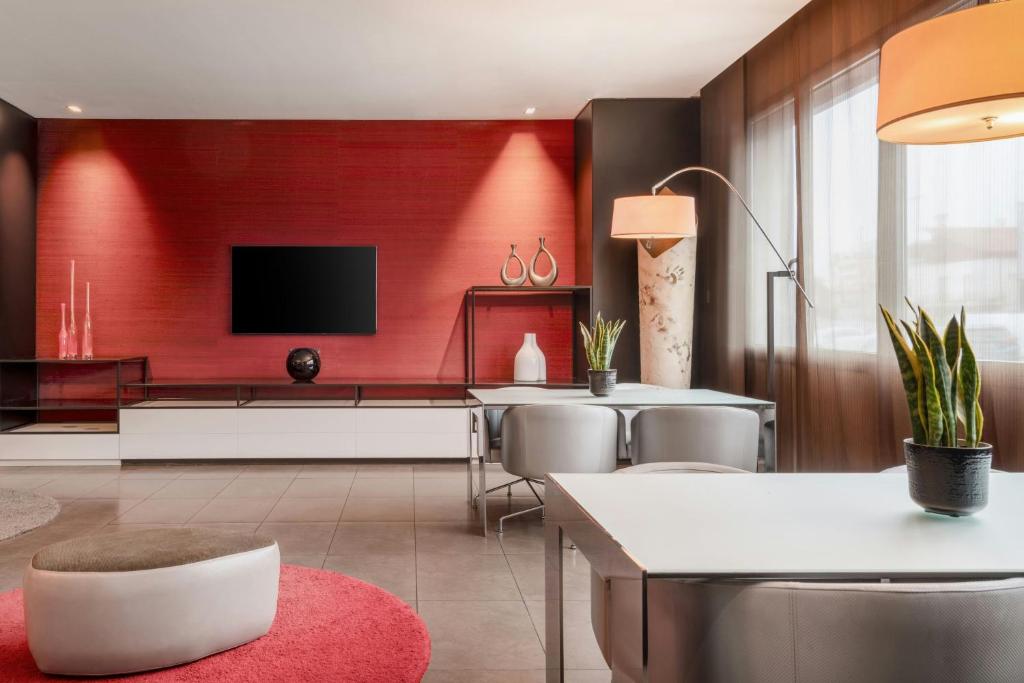a living room with a red wall at AC Hotel Padova by Marriott in Padova