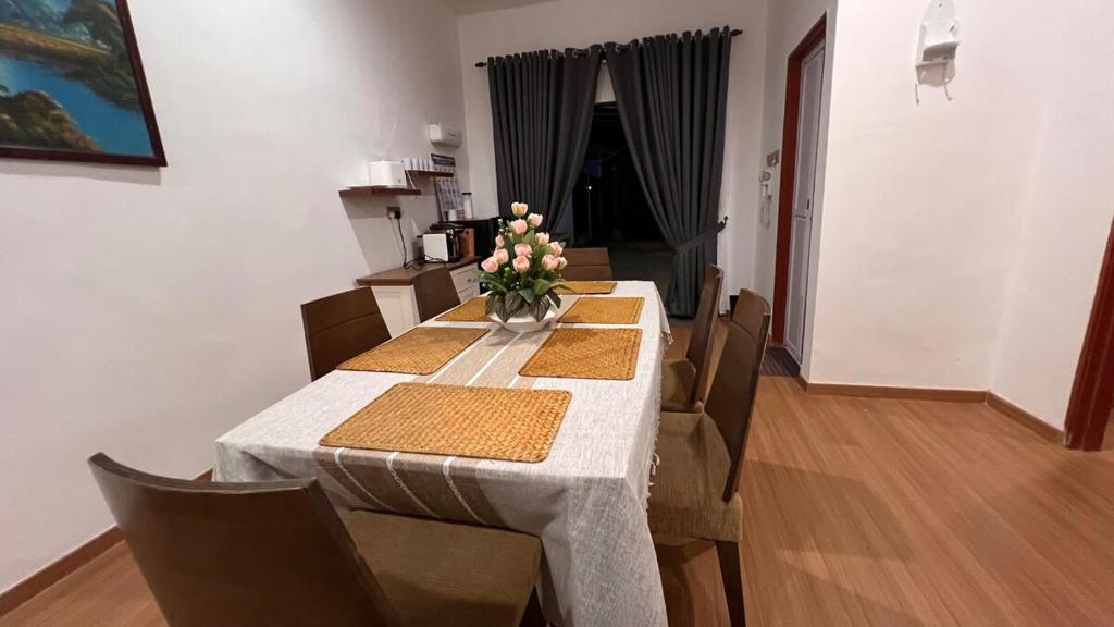 a dining room table with chairs and a vase of flowers at Serene Private Villa Kangar in Kangar