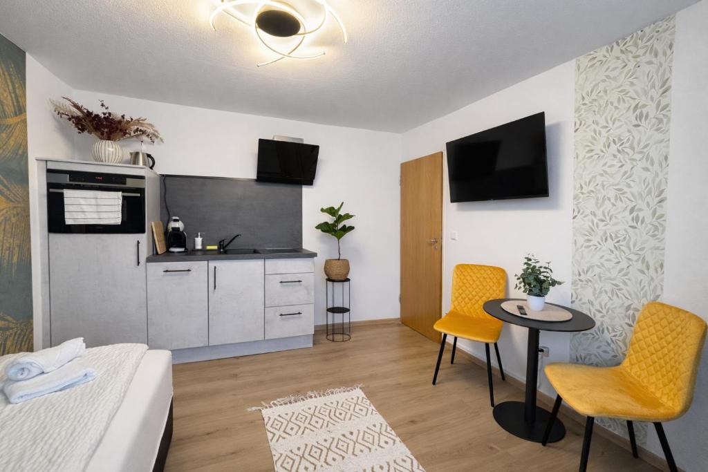 a living room with a kitchen and a table and chairs at Deluxe Studio Bella in Backnang