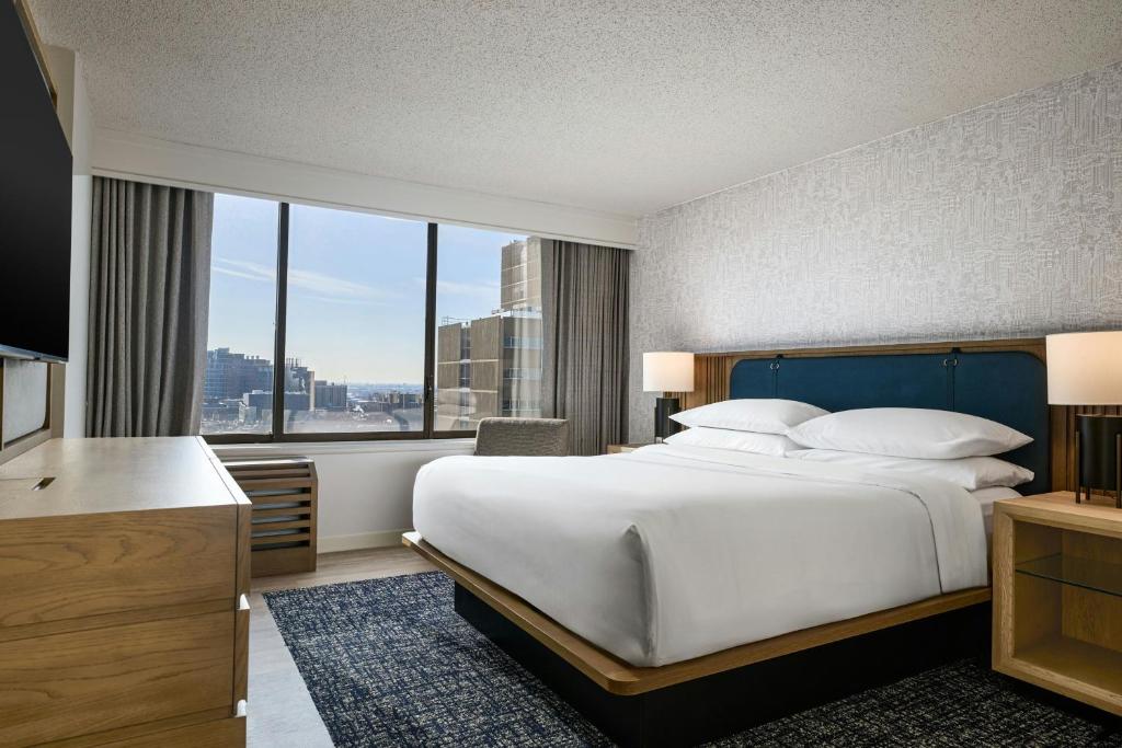 a hotel room with a large bed and a large window at Sheraton Philadelphia University City Hotel in Philadelphia
