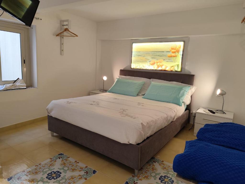 a bedroom with a large bed with a painting on the wall at L'altra opera in Palermo