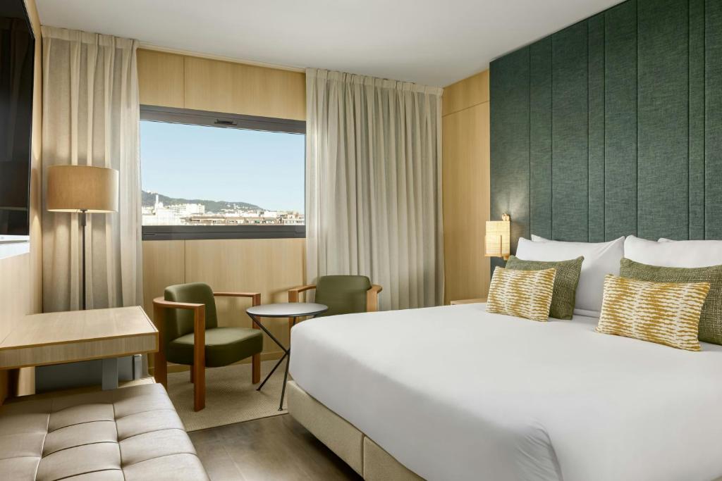 a hotel room with a bed and a table and chairs at AC Hotel Sants by Marriott in Barcelona
