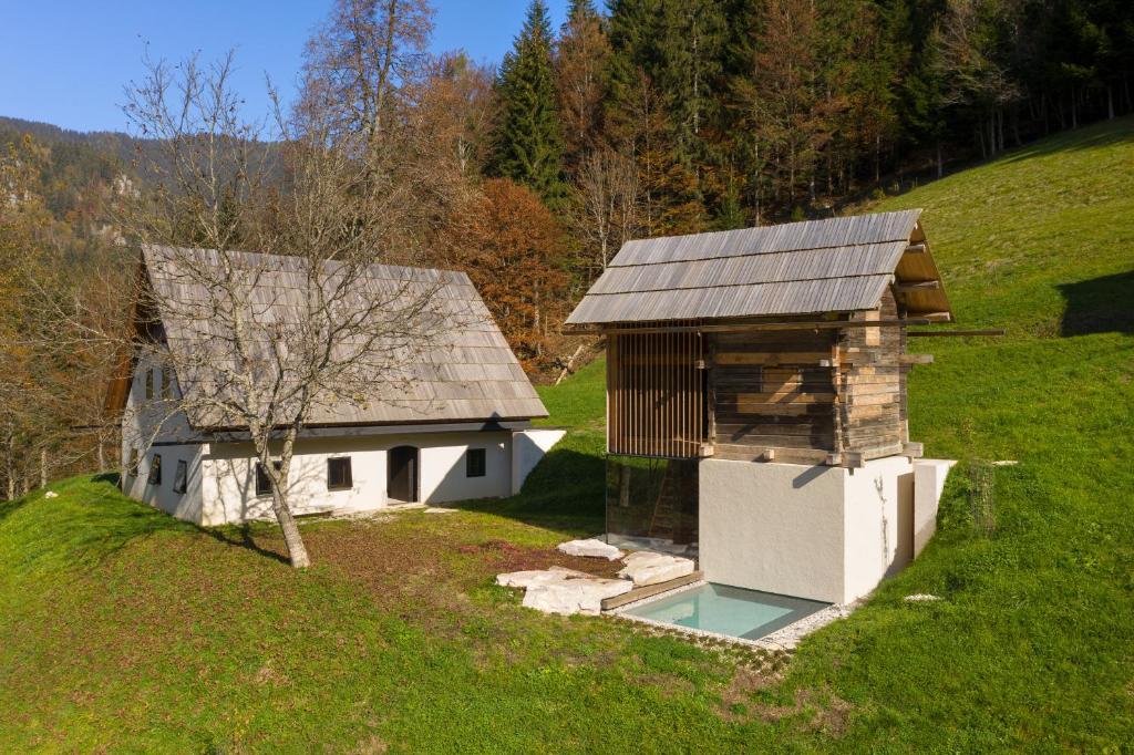 a house with a swimming pool next to a building at Alpine Contrapposto in Solčava