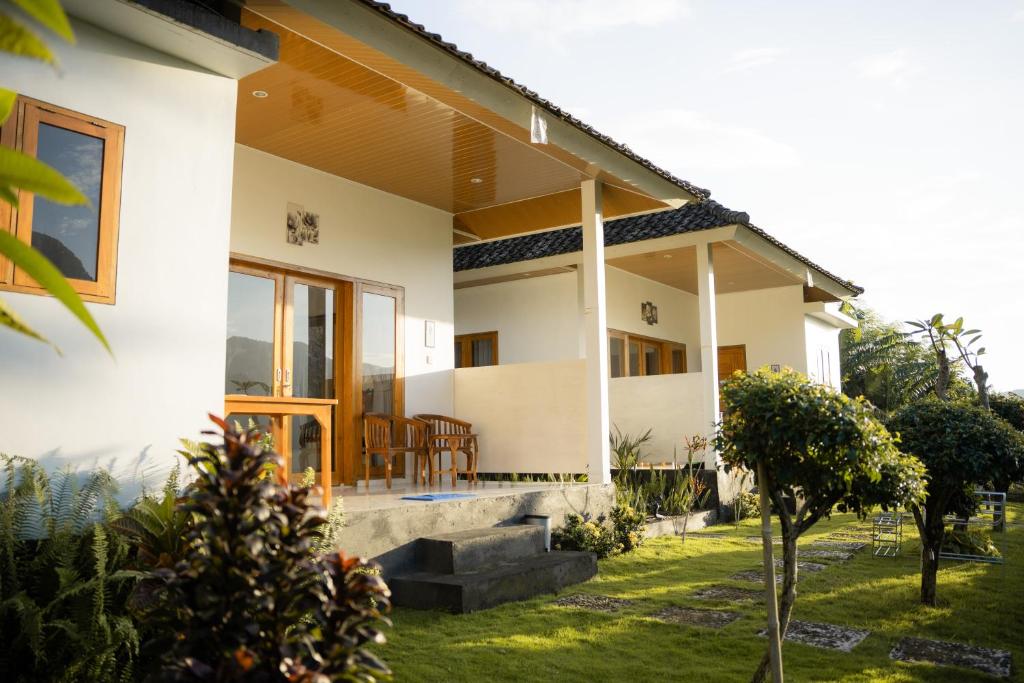 a white house with a porch and a yard at Melaka Hill in Culik