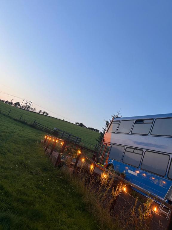 a train with lights on it in a field at The Bru Bus in Maybole