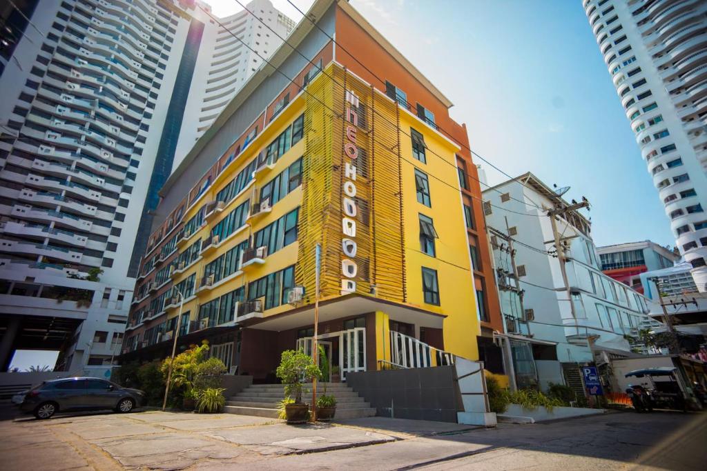 a yellow building in the middle of a city at Neo Hotel Pattaya in Jomtien Beach