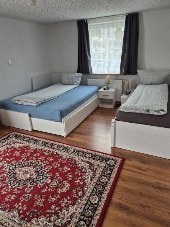 a bedroom with two beds and a rug at Ferienwohnung Selb in Selb