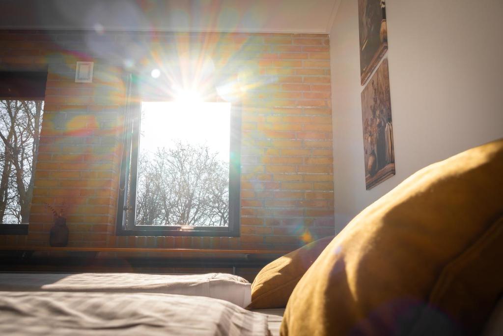 a bedroom with a brick wall and a window at Hotel Svanegården in Korsør