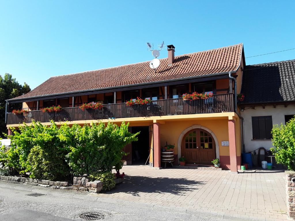 a building with a balcony and flowers on it at Chambres d'Hôtes Arnold in Dambach-la-Ville