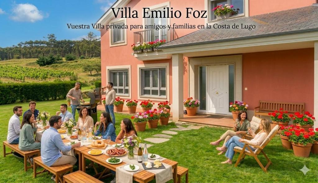 a group of people sitting around a table in a yard at Villa Emilio Foz in Foz