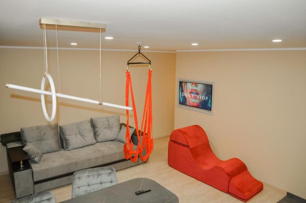 a living room with a couch and an orange swing at Merķeļa apartamenti in Valka