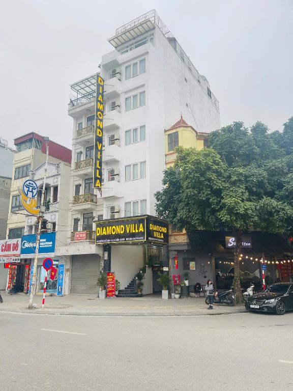 a large white building with a sign in front of it at Diamond Villa in Hanoi