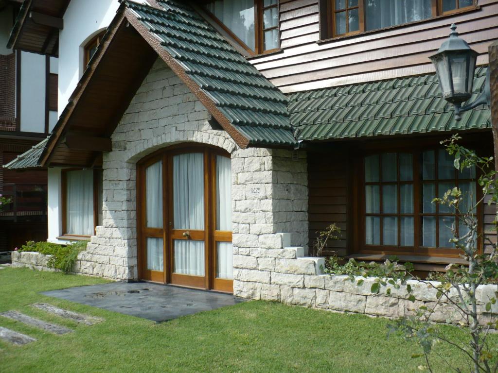 Casa con puerta de madera y techo verde en Complejo Frente al Golf en Pinamar